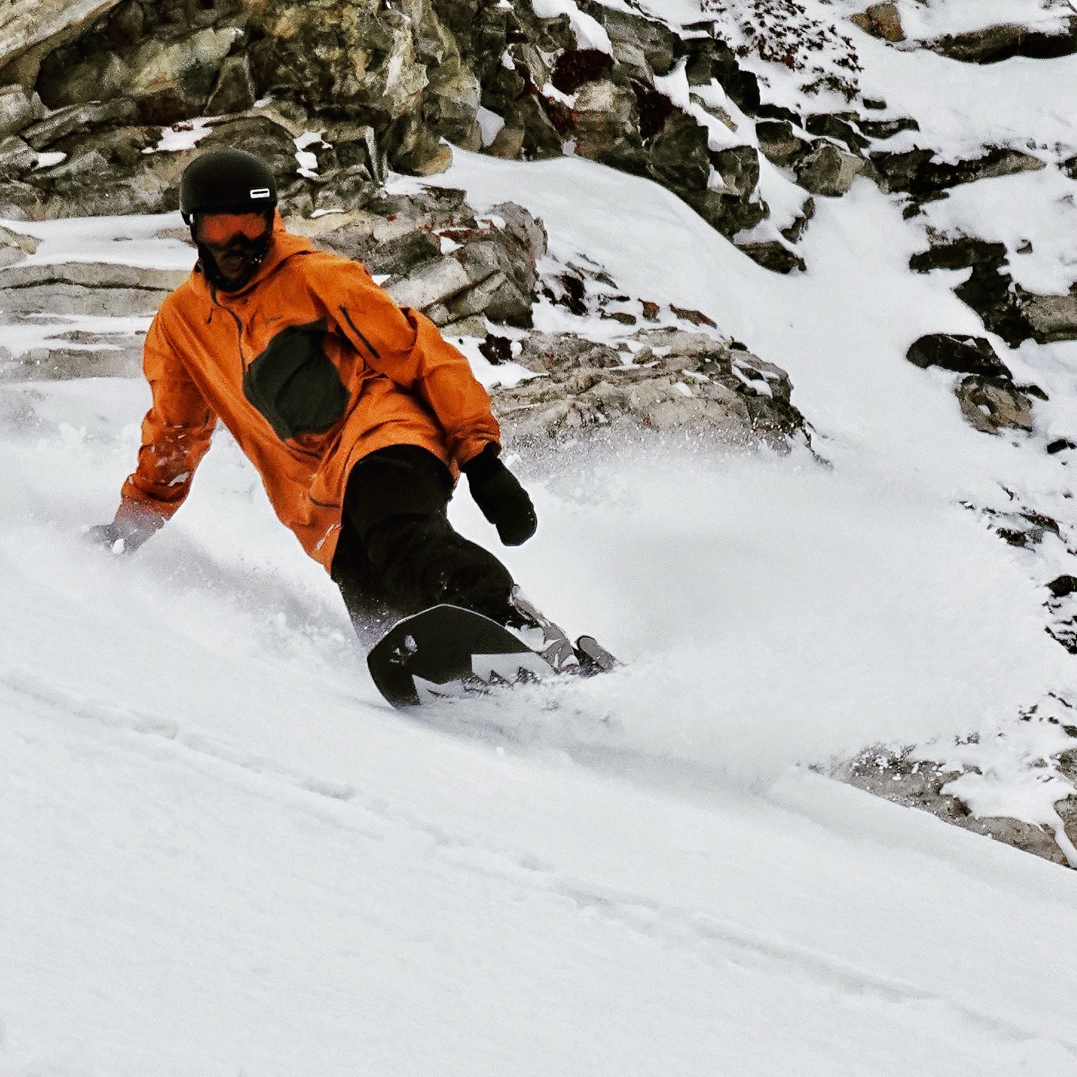 Ryan Hudson lays down a slash snowboarding at Snowbird, UT.