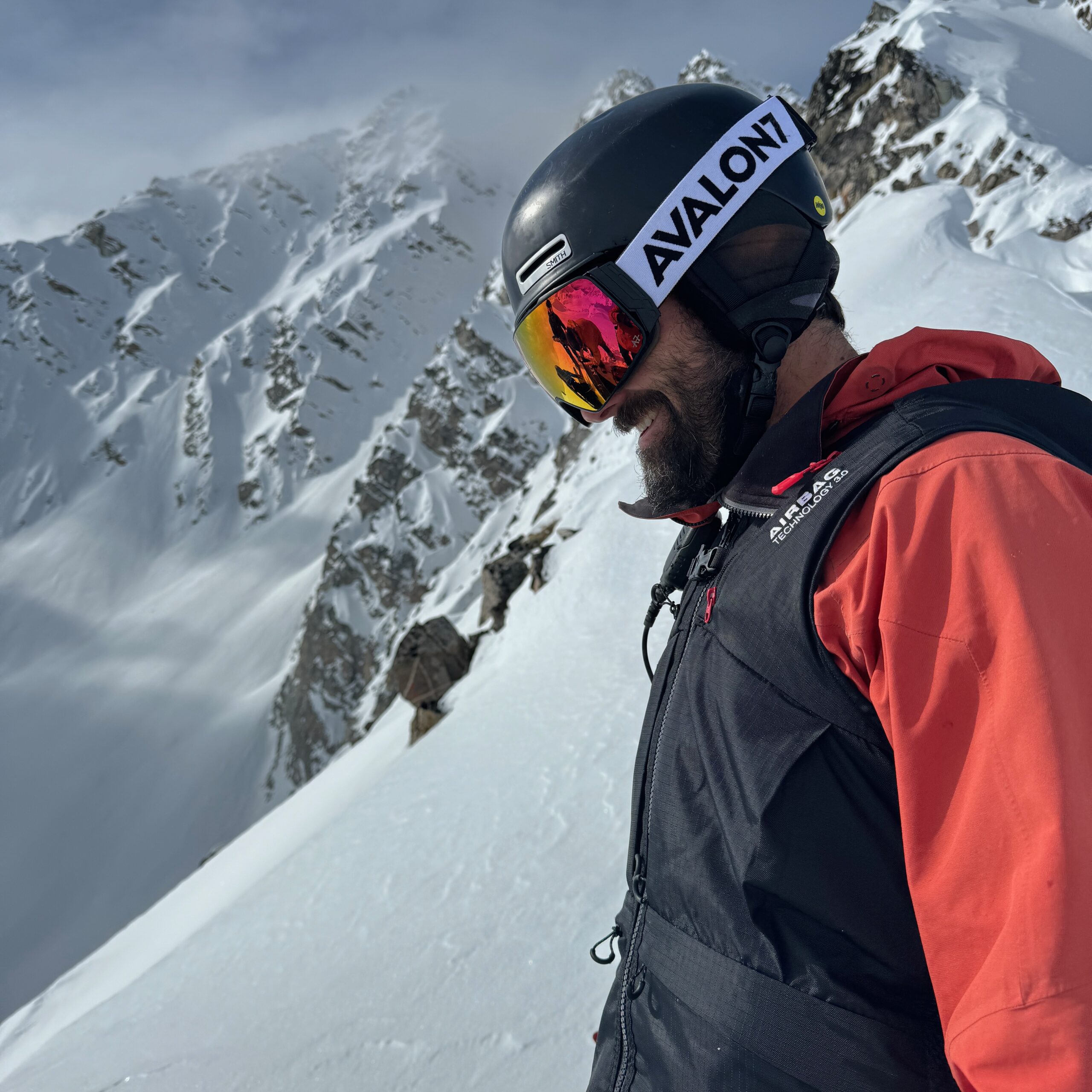 Snowboarder in the mountains wearing red AVALON7 magnetic goggles.